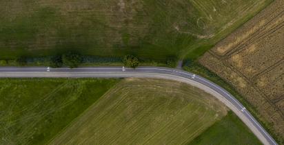 Widok z lotu ptaka na krętą drogę przebiegającą przez pola uprawne