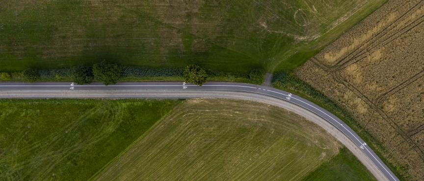 Widok z lotu ptaka na krętą drogę przebiegającą przez pola uprawne